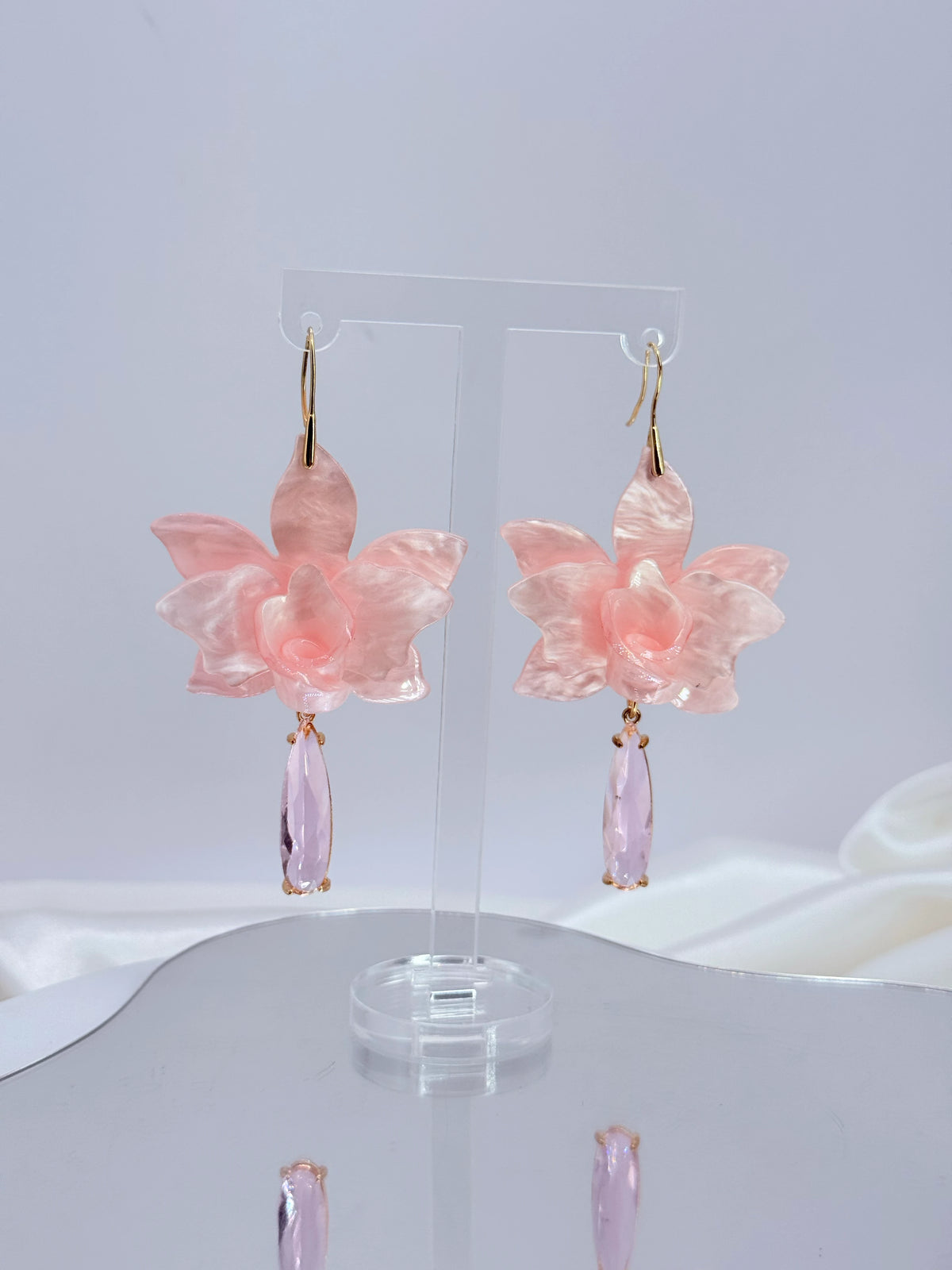 Aros flor de acrílico rosa pastel con gota de cristal y baño de oro