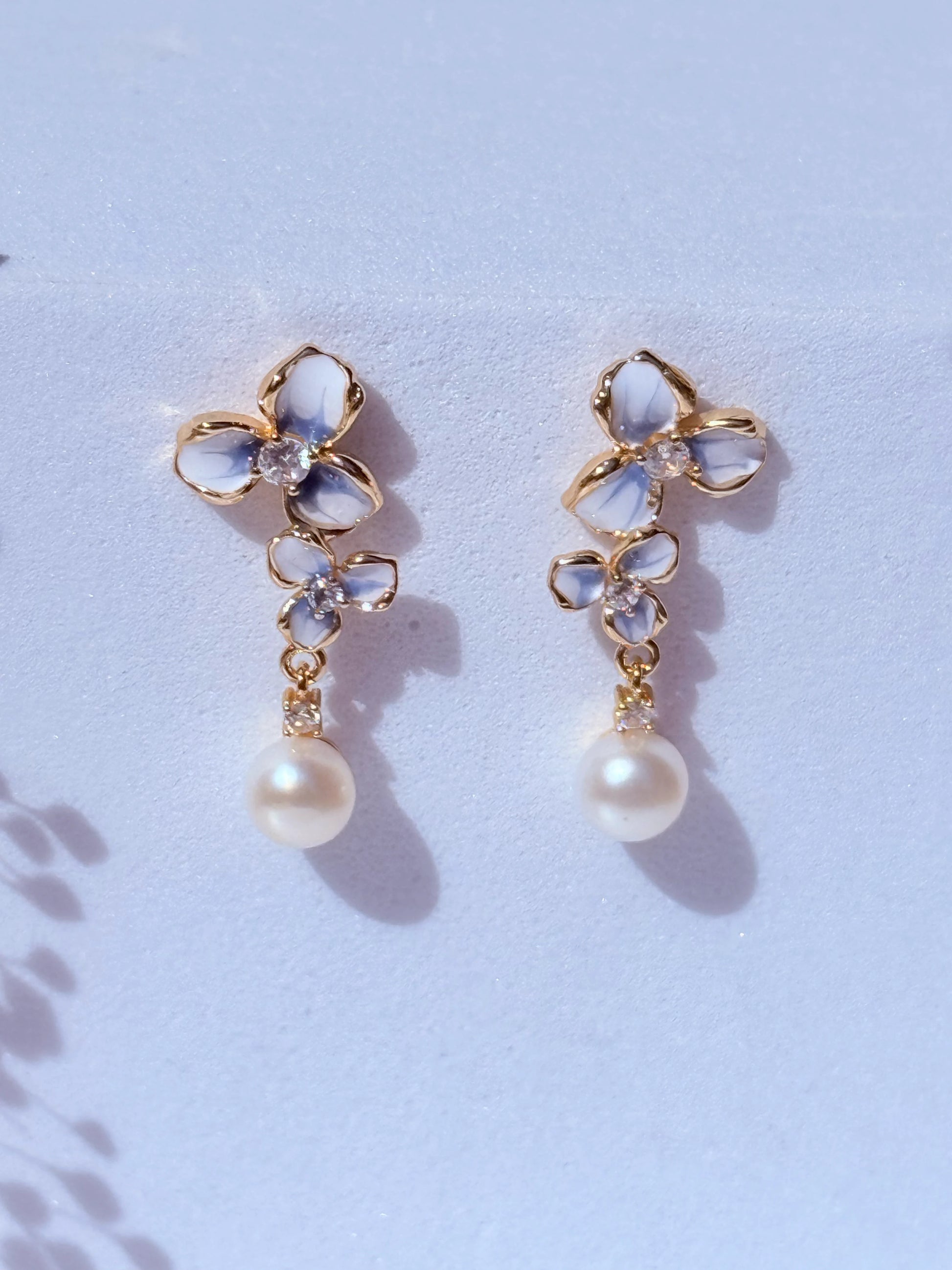 Aros pintados a mano en blanco y azul con perla natural  hipoalergénicos bañados en oro 