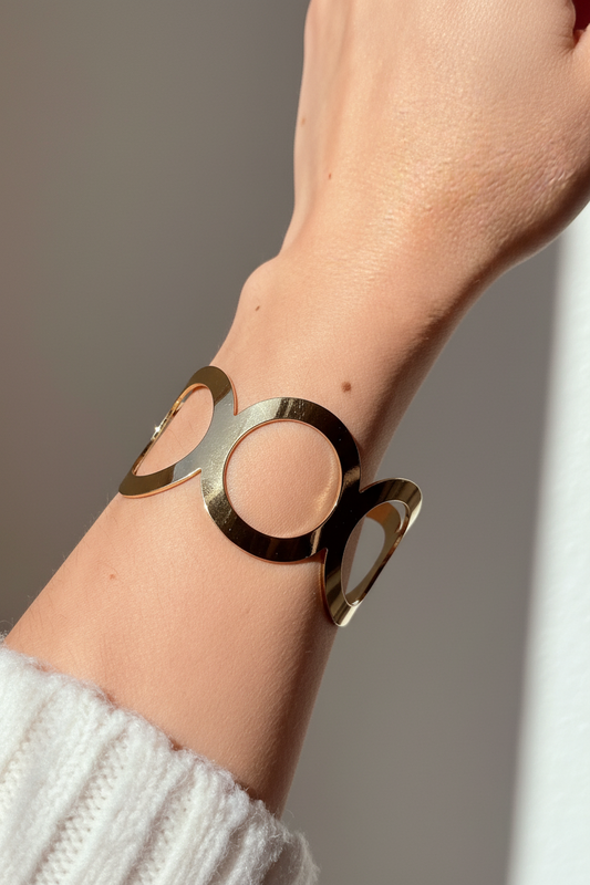 Pulsera tipo brazalete bañada en oro 18K mostrada en muñeca, diseño moderno y elegante