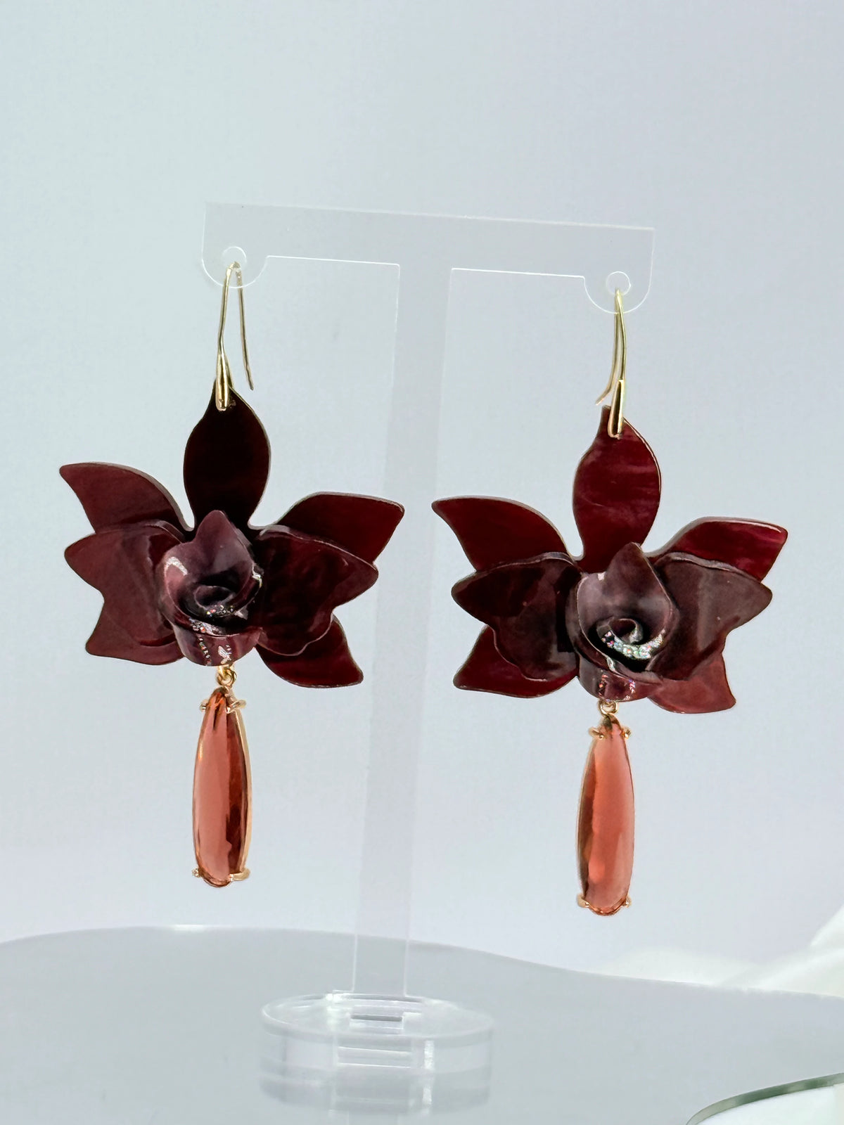 Aros flor de acrílico color vino con gota de cristal y baño de oro