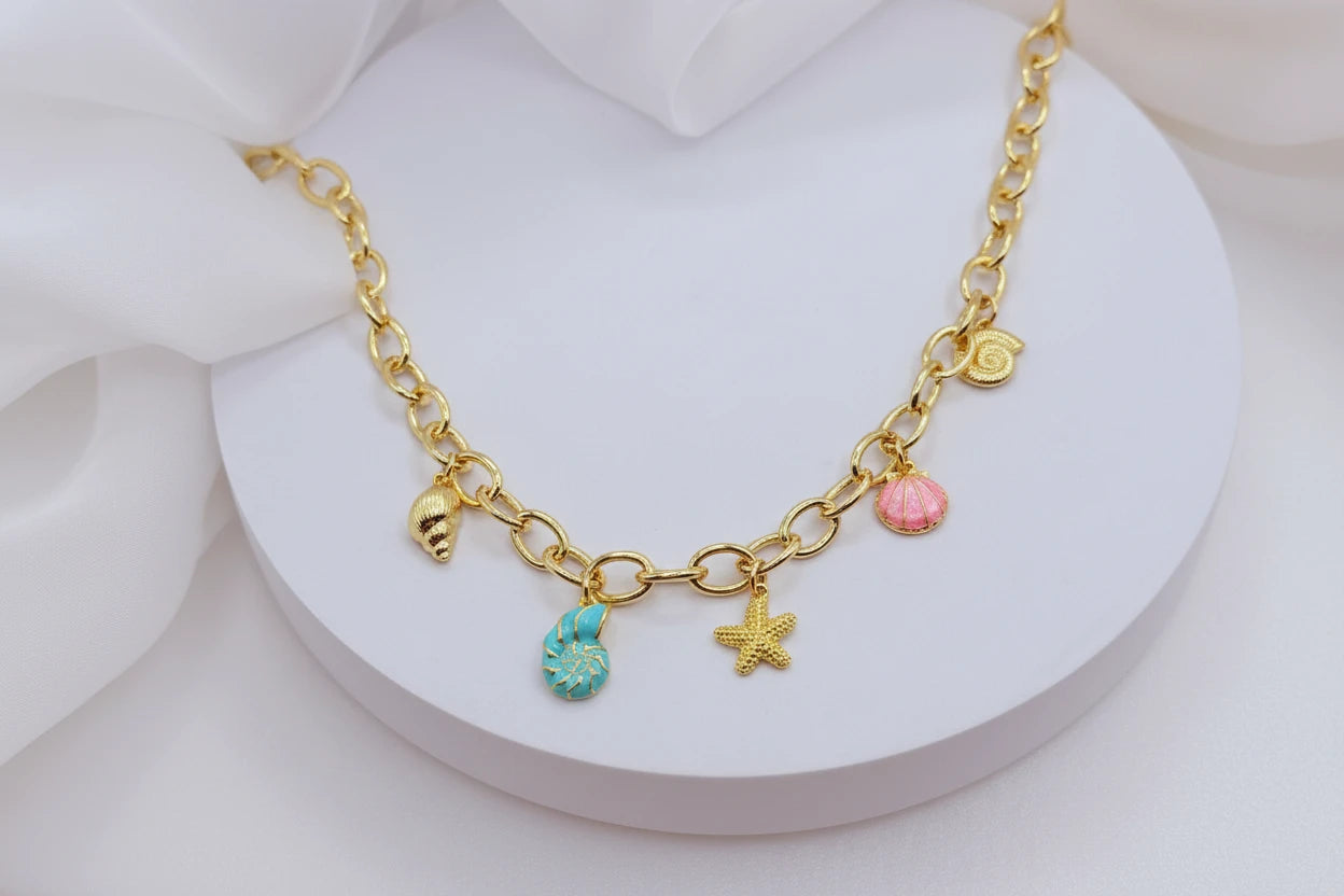 Collar con dijes marinos y cadena de eslabones bañado en oro. Perfecto para looks veraniegos y para regalar en ocasiones especiales